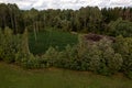 Drone photography of a pile of logs near a rural dirt road and logging site