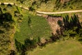 Drone photography of a pile of logs near a rural dirt road and logging site