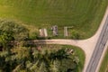 Drone photography of a pile of logs near a rural dirt road