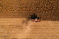 Drone photography of red combine harvester harvesting ripe rapeseed crop plantation field in summer, aerial shot Royalty Free Stock Photo