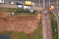 Drone photography of sewage pipe being lade down i a ditch by a road during autumn day