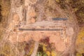 Drone photography of sewage pipe being lade down i a ditch by a road during autumn day