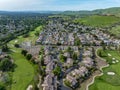 Drone photos over the Oakhurst neighborhood in Clayton, California with green hills, golf course and homes