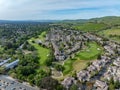 Drone photos over the Oakhurst neighborhood in Clayton, California with green hills, golf course and homes