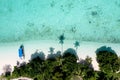 Drone point of view of tropical island Maiga with palm trees and turquoise colored sea