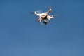 Drone quad copter fly on blue sky in background. Modern drone is flying in air, to take photos and record footage from above. Royalty Free Stock Photo