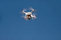 Drone quad copter fly on blue sky in background. Modern drone is flying in air, to take photos and record footage from above. Royalty Free Stock Photo