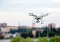 Drone quad copter with high resolution digital camera flying hovering over the city. Royalty Free Stock Photo