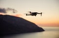 Drone quadcopter with digital camera flying over coast at sunset Royalty Free Stock Photo