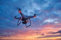 Drone quadcopter with digital camera flying at sunset Royalty Free Stock Photo