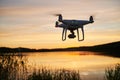 Drone quadcopter with digital camera flying at sunset Royalty Free Stock Photo