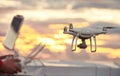 Drone quadcopter with digital camera flying at sunset Royalty Free Stock Photo