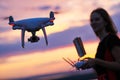 Drone quadcopter with digital camera operated by woman at sunset Royalty Free Stock Photo