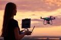 Drone quadcopter with digital camera operated by woman at sunset Royalty Free Stock Photo