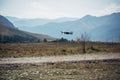 Drone quadcopter UAV with digital camera flying on the background with mountain, blue sky and white clouds. Professional drone Royalty Free Stock Photo