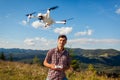 Drone remote control. Man operating copter controller in mountains. Aerial video shooting of summer Carpathins Royalty Free Stock Photo