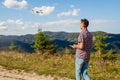 Drone remote control. Man operating copter controller in mountains. Aerial video shooting of summer Carpathins Royalty Free Stock Photo