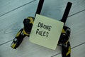 Drone Rules write on sticky notes isolated on Wooden Table