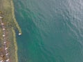 Drone shot. Birds view of clear lake with trees and buildings