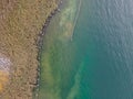 Drone shot. Birds view of clear lake with trees and buildings