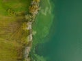 Drone shot. Birds view of clear lake with trees and buildings