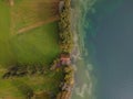 Drone shot. Birds view of clear lake with trees and buildings