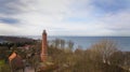 A drone captures Gaski beach, West Pomeranian Voivodeship, Poland, featuring a red brick lighthouse, Baltic Sea, sandy shore,