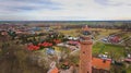 A drone captures Gaski beach, West Pomeranian Voivodeship, Poland, featuring a red brick lighthouse, Baltic Sea, sandy shore,