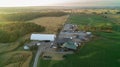 A drone shot of a farmhouse, farm fields and Barns