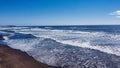 Drone shot of foamy waves crashing the Goat Rock beach of Jenner, California, USA