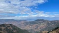 Drone shot of hills covered with green trees under the blue cloudy sky Royalty Free Stock Photo