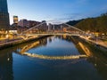 Drone shot over Bilbao cityscape and Zubizuri bridge at sunset in Bilbao, Spain Royalty Free Stock Photo