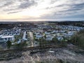 Drone shot of residential buildings and houses in a town near a field with cut trees Royalty Free Stock Photo