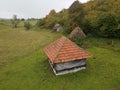 Drone shot of a rural wooden cottage in a large green field in Sjenica, Serbia Royalty Free Stock Photo