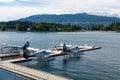 Drone shot of seaplanes on the harbor in Vancouver, Canada against green-covered hills
