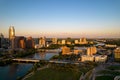 Drone shot of TX skyline with waterfront, greenery and blue sky at sunset in Austin city