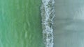 Drone shot of waves on a white sand beach