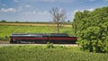 Drone Side View of an Antique Steam Engine, Approaching, Blowing Steam and Traveling Along the Countryside Royalty Free Stock Photo