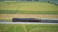 Drone Side View of an Antique Steam Engine, Approaching, Blowing Steam and Traveling Along the Countryside Royalty Free Stock Photo