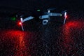 Drone with signal lights reflecting in wet asphalt surface