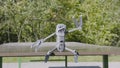 Drone is sitting on table. Action. Funny figure from drone sitting on table in Park. Robotic drone sits and amusingly