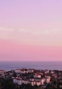 Drone vertical shot of a cityscape with sea at sunset