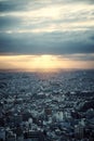 Drone vertical shot of a cityscape under cloudy sky at sunset