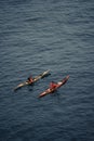 Drone vertical shot of two people kayaking on the sea
