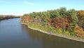 Drone video flying backward over the quiet river, on a clear sunny day, in the Fall, between an island and the shore of Rosemere