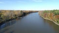 Drone video flying over the quiet river, on a clear sunny day, in the Fall, between an island and the shore of Rosemere