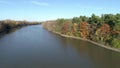 Drone crane video coming down over the quiet river, on a clear sunny day, in the Fall, between an island and the shore of Rosemere