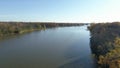 Drone video panning from behind a naked tree, in the Fall, and moving over the river, in Rosemere