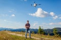 Drone video shooting of summer Carpathins. Man operating copter controller in mountains. Tourist filming nature Royalty Free Stock Photo