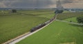 Drone View of an Antique Steam Engine, Approaching, Blowing Steam and Traveling Along the Countryside Royalty Free Stock Photo